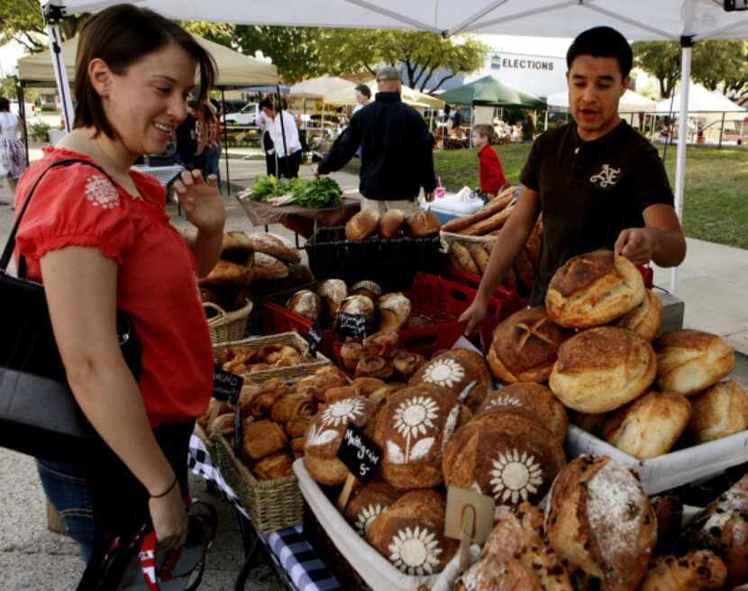 Ivan Paniagua, right, helps customer Erin Erwin of Rockwell with a selection of bread at the...