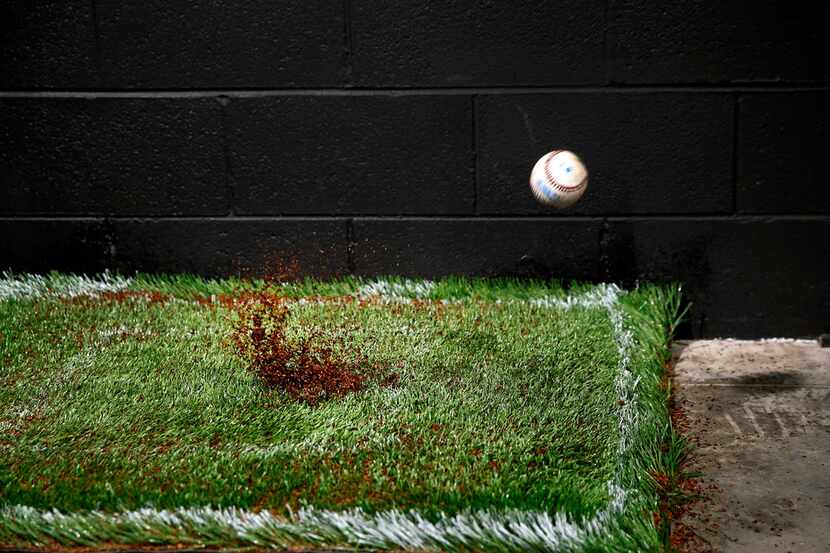 A baseball is fired at 85-100 mph at a turf sample in the Shaw Sports Turf's indoor...