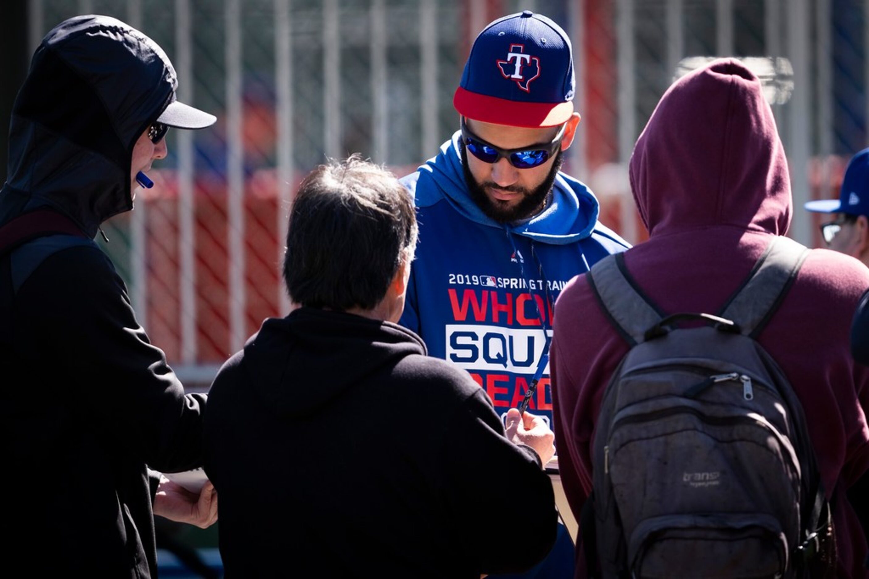 Texas Rangers outfielder Nomar Mazara pauses between drills to sign autographs during a...