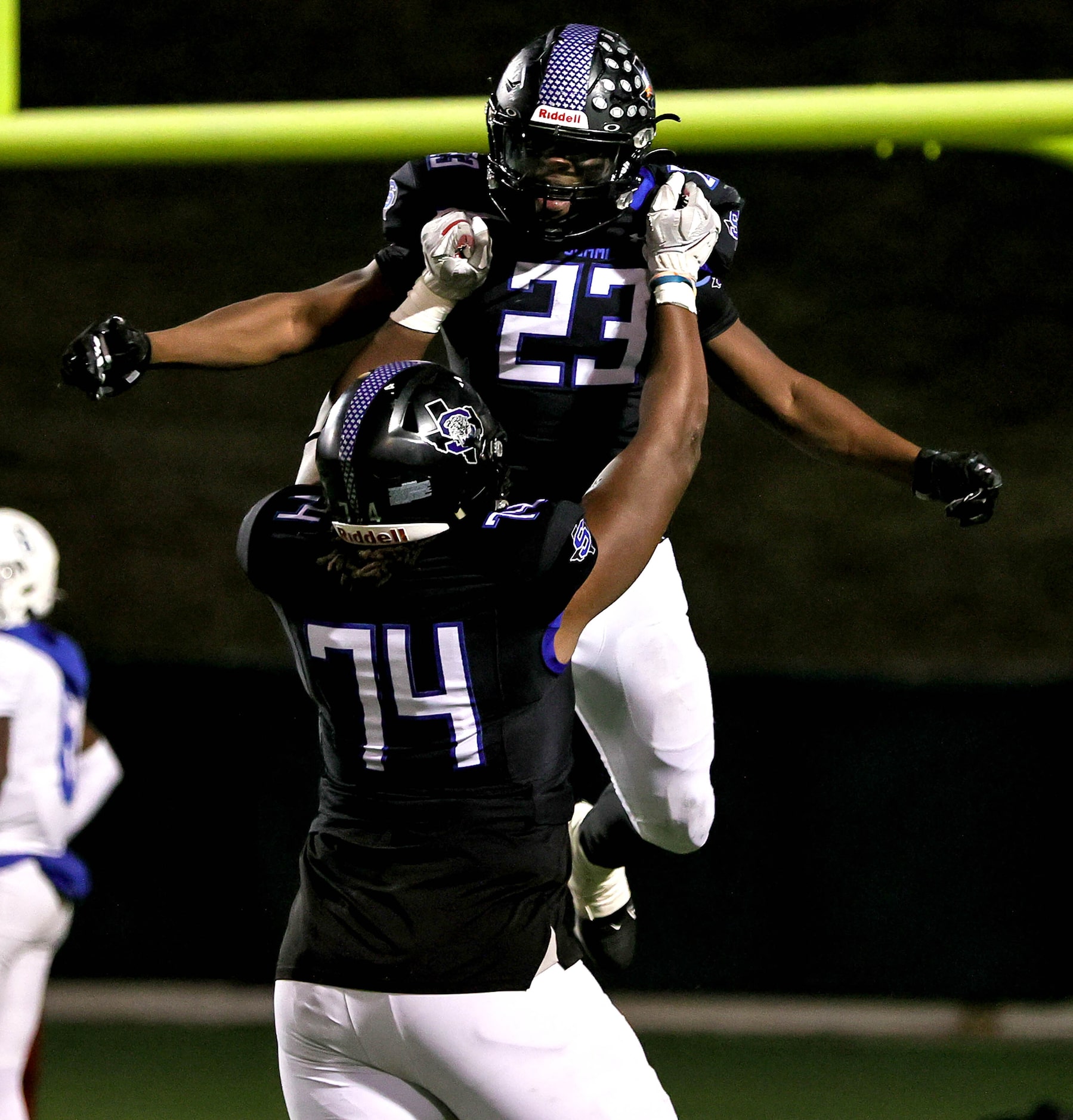 Mansfield Summit running back Orlando Scales (23) gets hold up by offensive lineman Shahid...