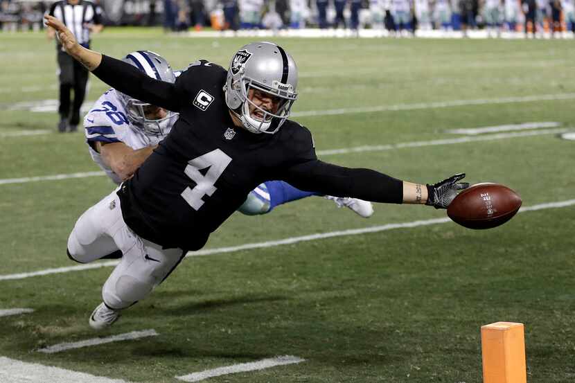Oakland Raiders quarterback Derek Carr (4) fumbles the ball into the end zone after getting...