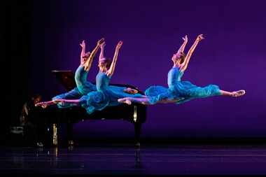 Three female ballet dancers leap across the stage.