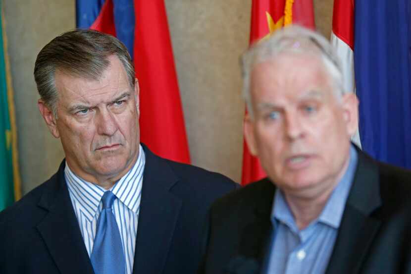 Mayor Mike Rawlings (left) watches Neville R. Ray, Executive Vice President and Chief...