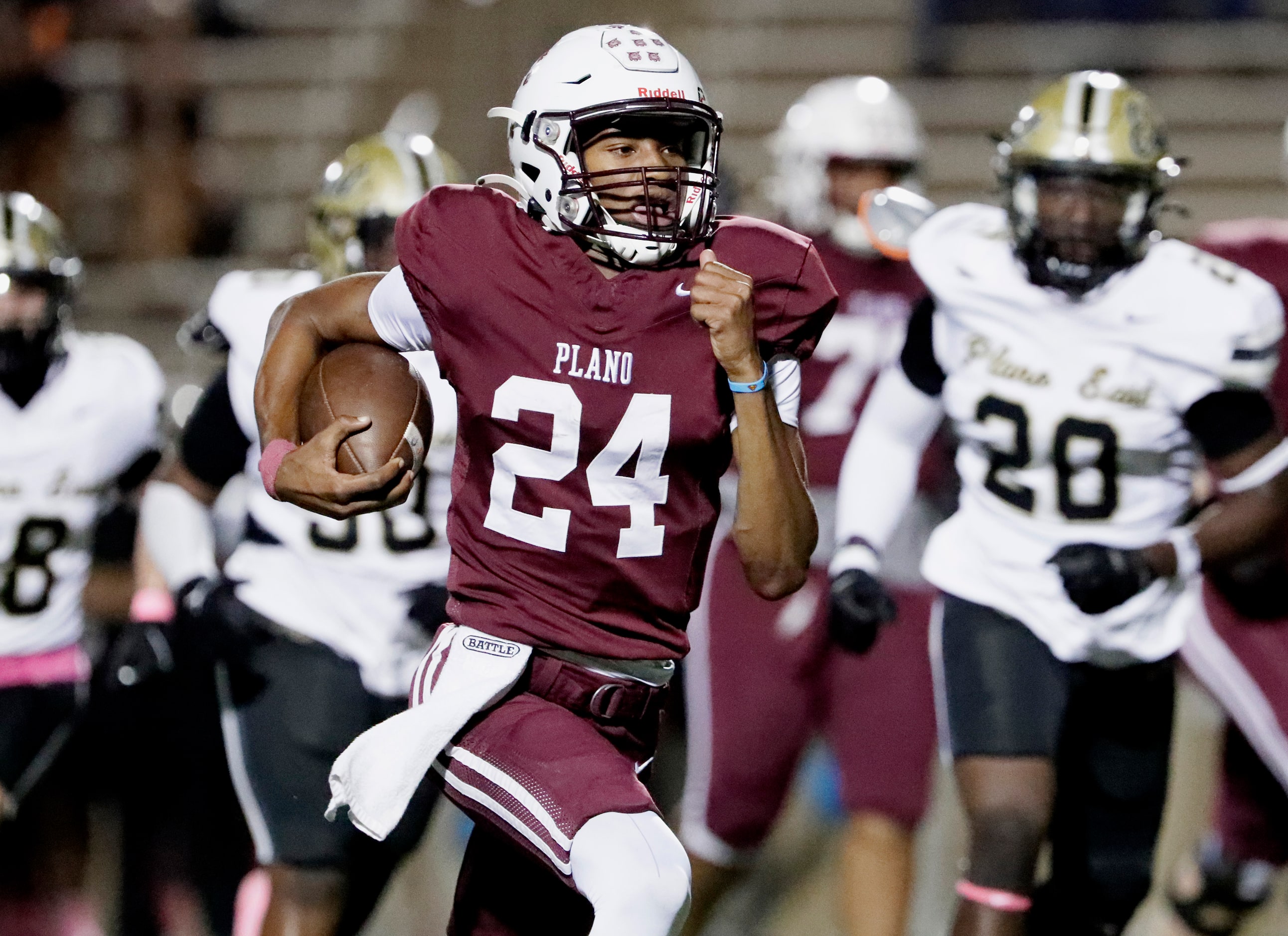 Plano High School quarterback Tyree Fisher (24) runs for a big gain during the first half as...