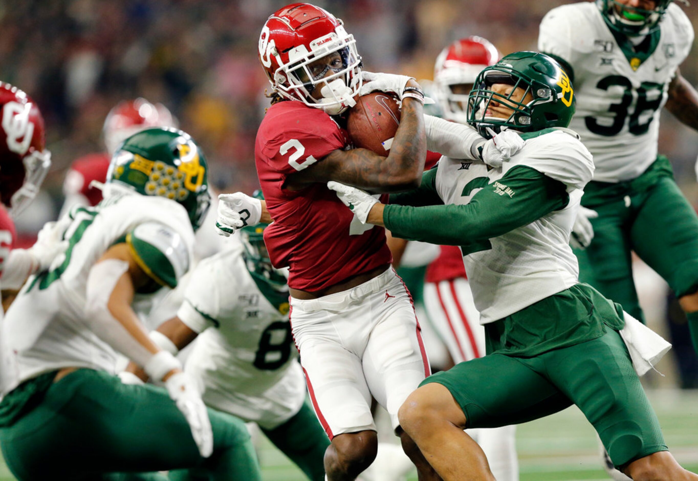 Oklahoma Sooners wide receiver CeeDee Lamb (2) protects the ball as he's tackled a bevy of...