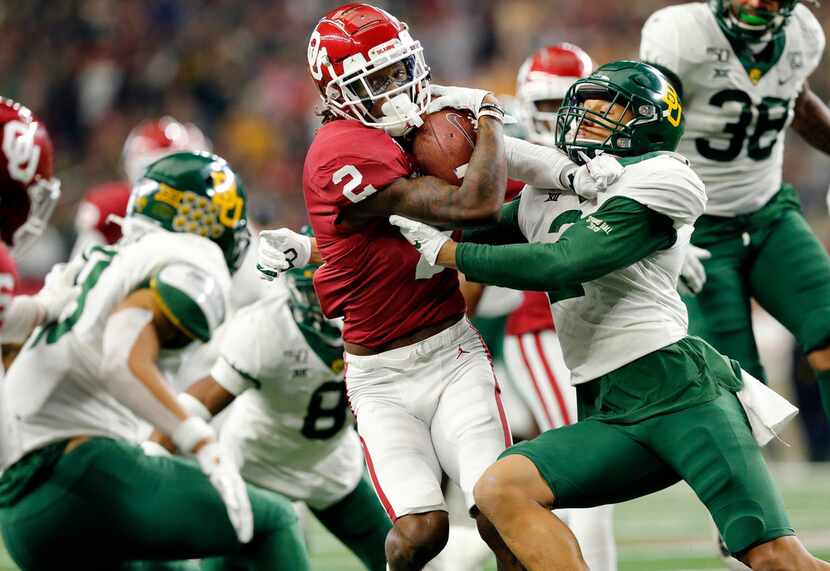 FILE - Oklahoma wide receiver CeeDee Lamb (2) secures the ball as he's tackled a bevy of...