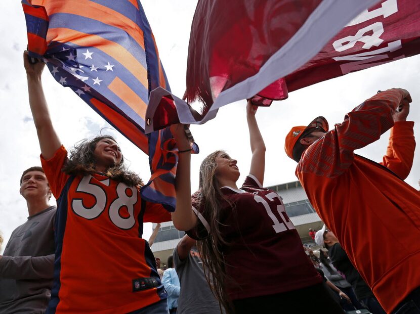 Valerie Ruiz, left, and her sister Vicky, fans of Denver Broncos linebacker Von Miller, wave...