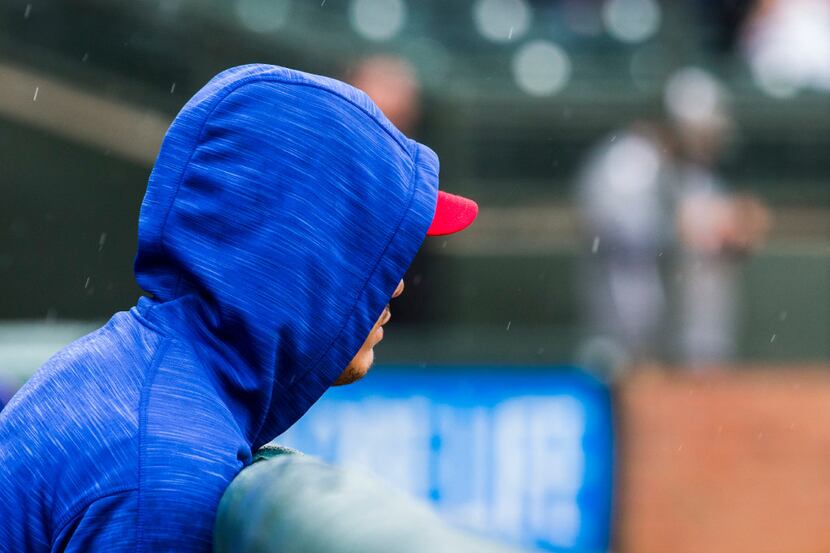 Texas Rangers left fielder Ryan Rua (16) leans against the railing of the dugout as rain...
