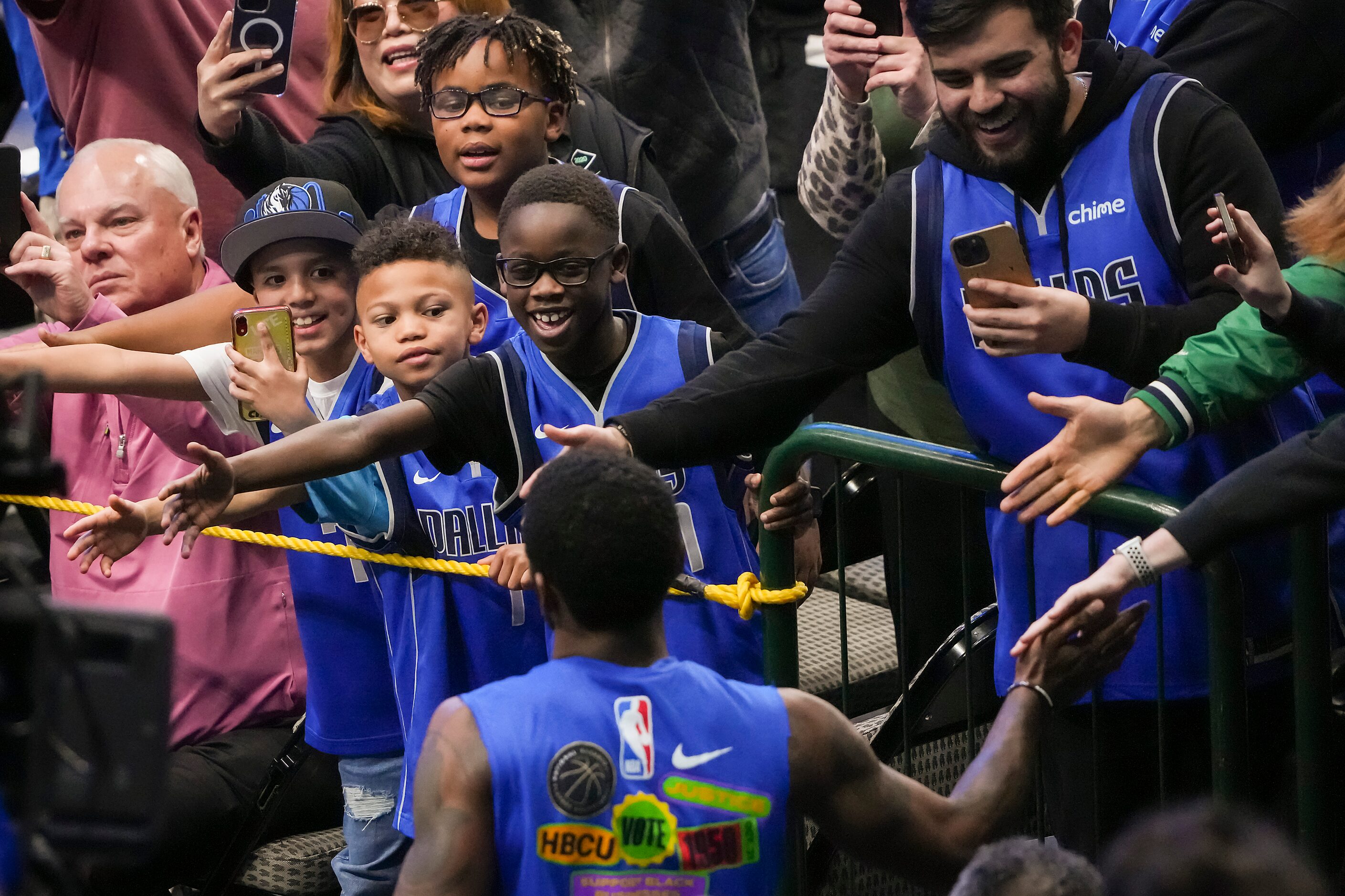 Fans reach out to Dallas Mavericks guard Kyrie Irving as he takes the court for his first...