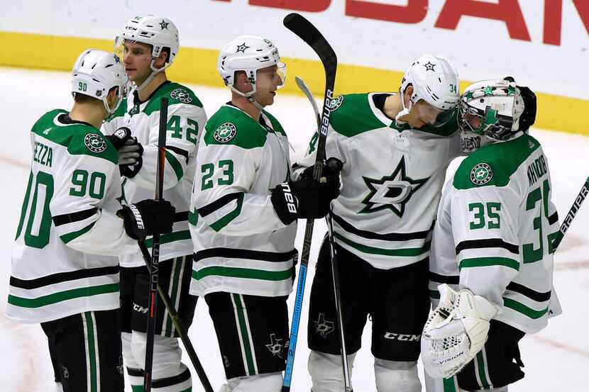 Dallas Stars goaltender Anton Khudobin (35), of Kazakhstan, is congratulated by teammates...