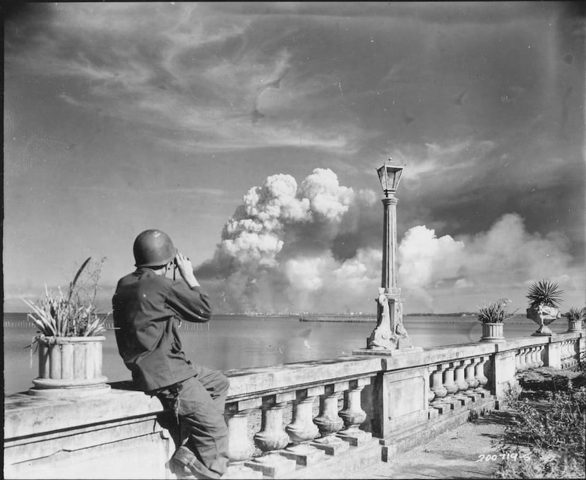 An American soldier watches Manila burn from the beach at Paranque on Feb. 8, 1945. From...