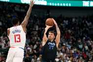 Dallas Mavericks guard Luka Doncic (77) shoots against LA Clippers forward Paul George (13)...