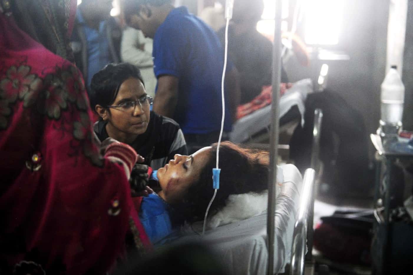 A relative keeps watch as an injured train passenger receives treatment at a hospital in...