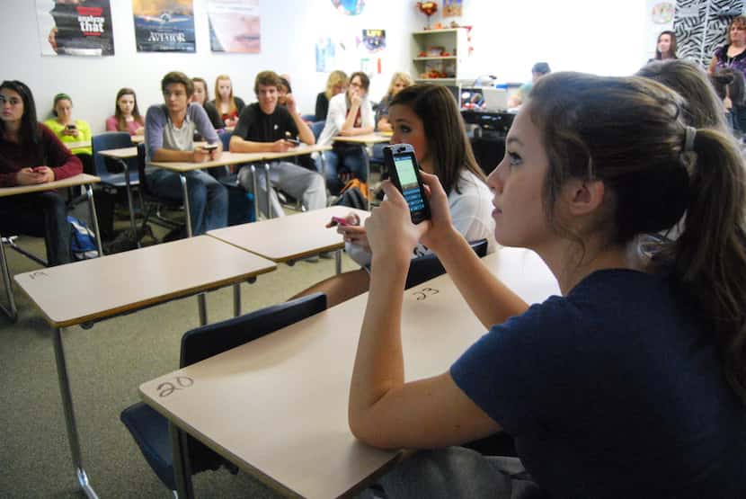 Rockwall High School student Emily Pettett uses her phone to text an answer to her AP...