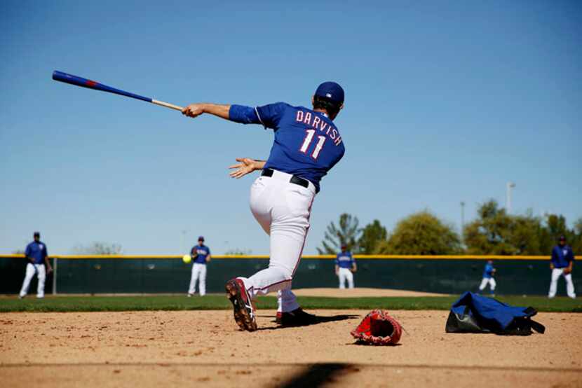  Texas Rangers pitcher Yu Darvish hits during a softball mock hitting and fielding game with...