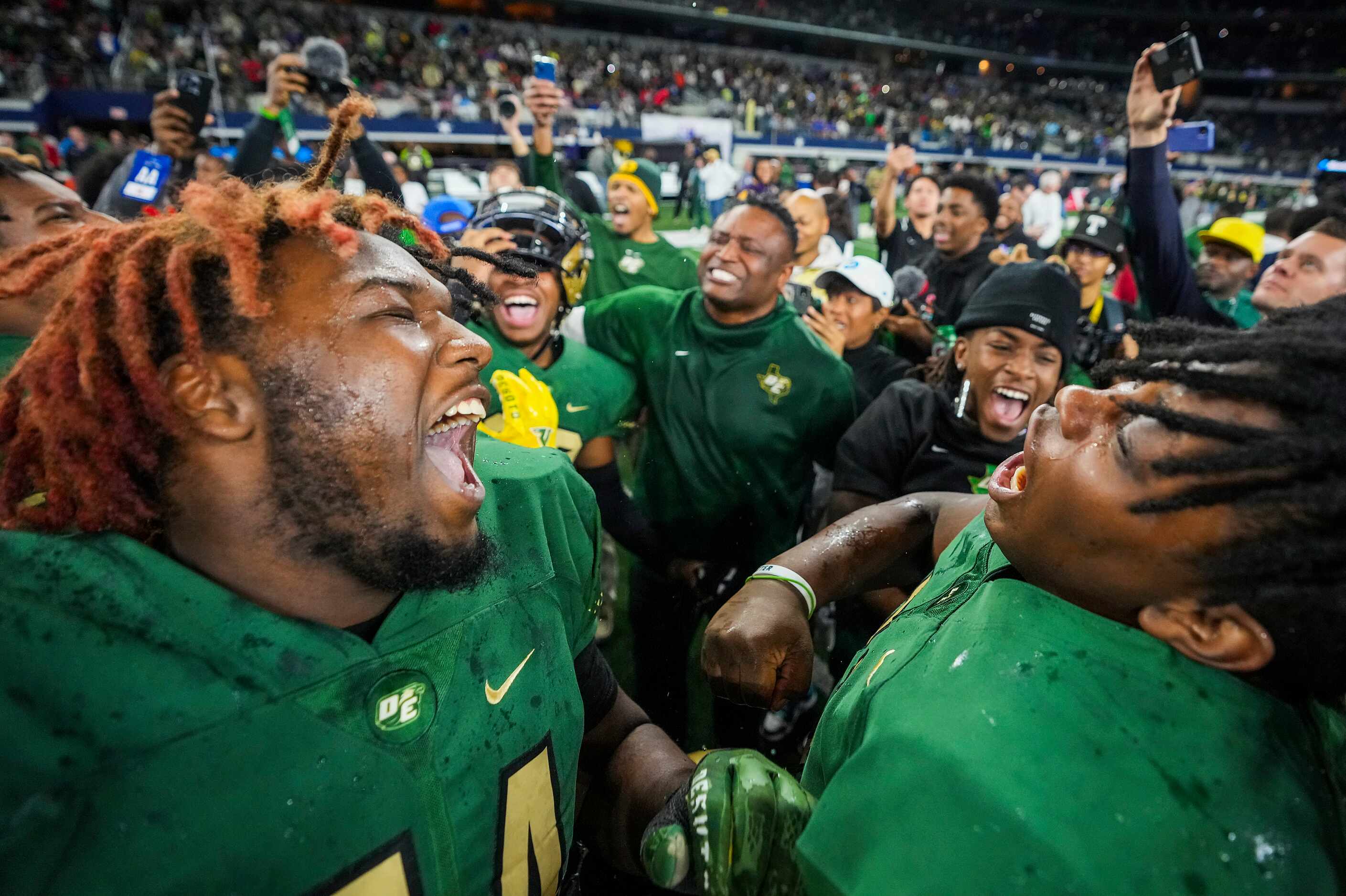 DeSoto defensive tackle Datayvion Veail (left) celebrates with his teammates after a victory...