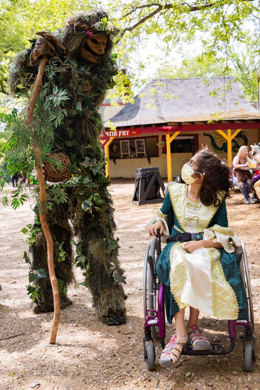 Layla Maeesomy, 12, of Plano spends a moment with Tree Man after taking a photo with him.