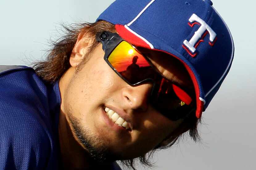 Texas Rangers pitcher Yu Darvish listens to his translator Joe Furukawa during spring...