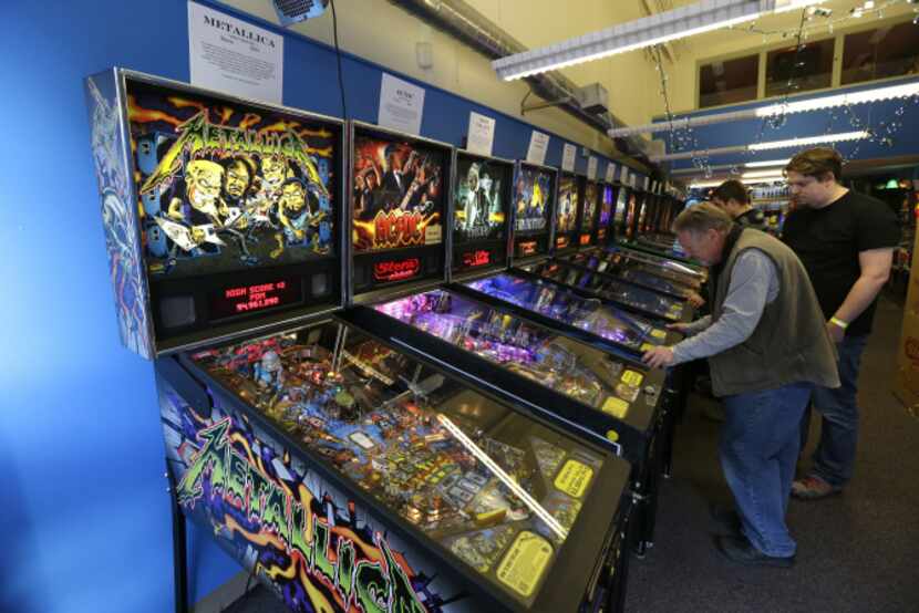 In this Dec. 16, 2013 photo, visitors play pinball on more modern machines at the Seattle...