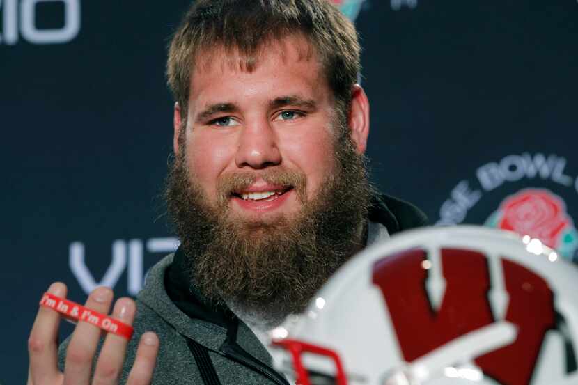 Wisconsin linebacker Travis Frederick holds up a rubber bracelet that says "I'm In & I'm On"...