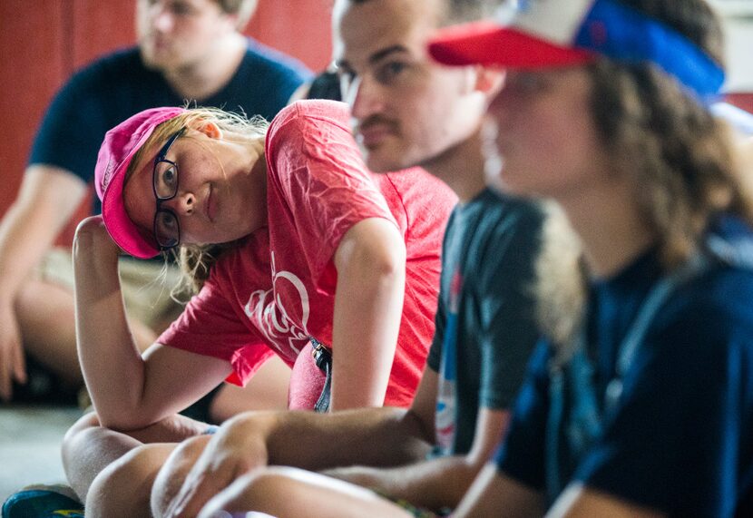 Austen Wheeler, 20, left, and other adults with autism listen to a program about animals at...