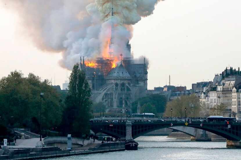 Smokes ascends as flames rise during a fire at the landmark Notre-Dame Cathedral in central...