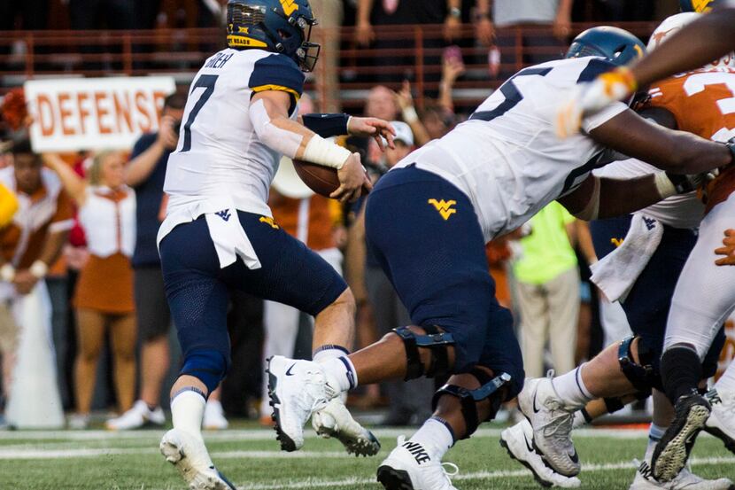 West Virginia Mountaineers quarterback Will Grier (7) runs the ball to the end zone for a...