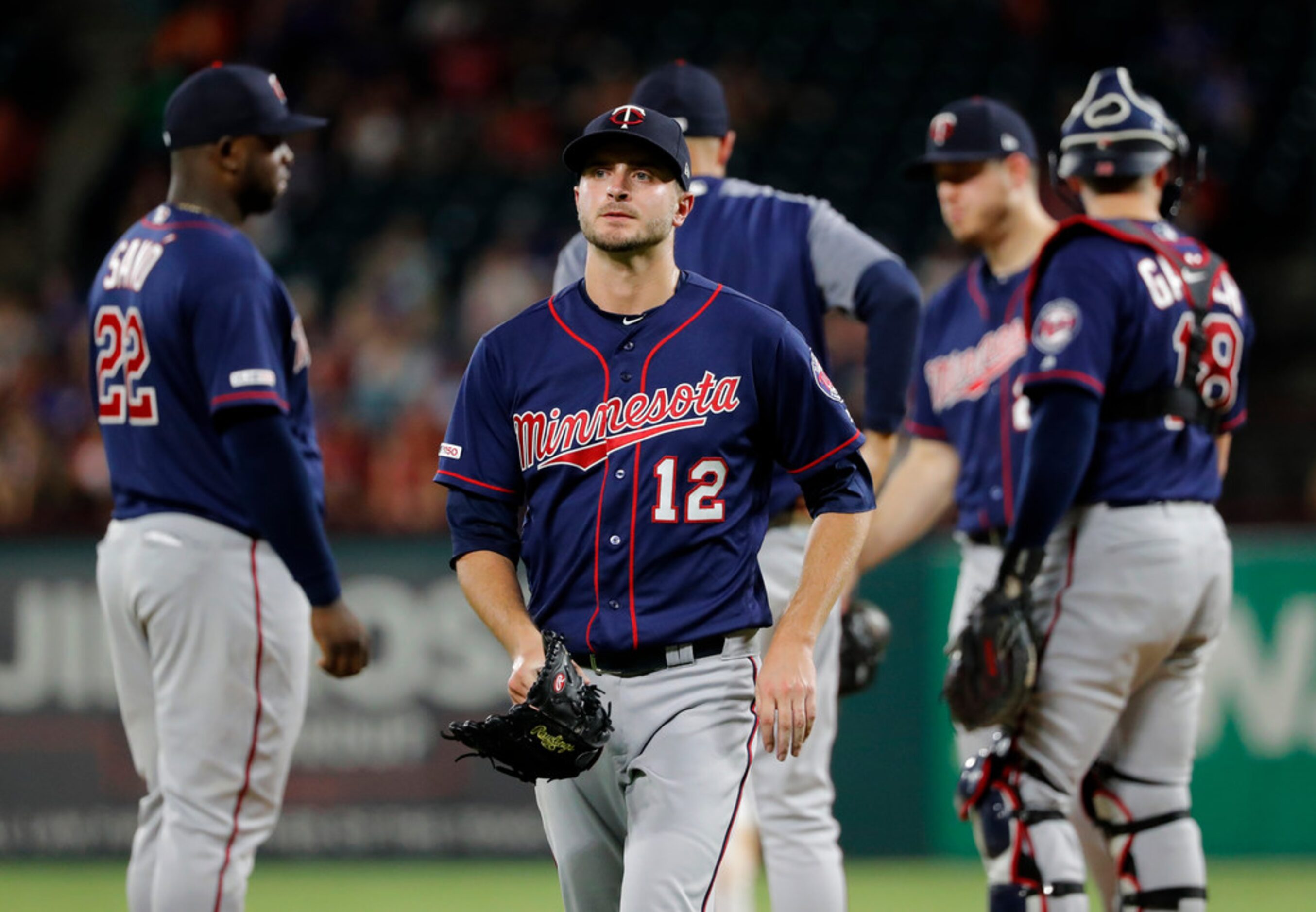 Minnesota Twins' Jake Odorizzi (12) walks to the dugout after turning the ball over to Rocco...