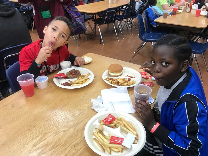 Chris Rokundo, 9, (left) and Daetin Sanders, 8,  eat lunch at Cowboy Camp. 