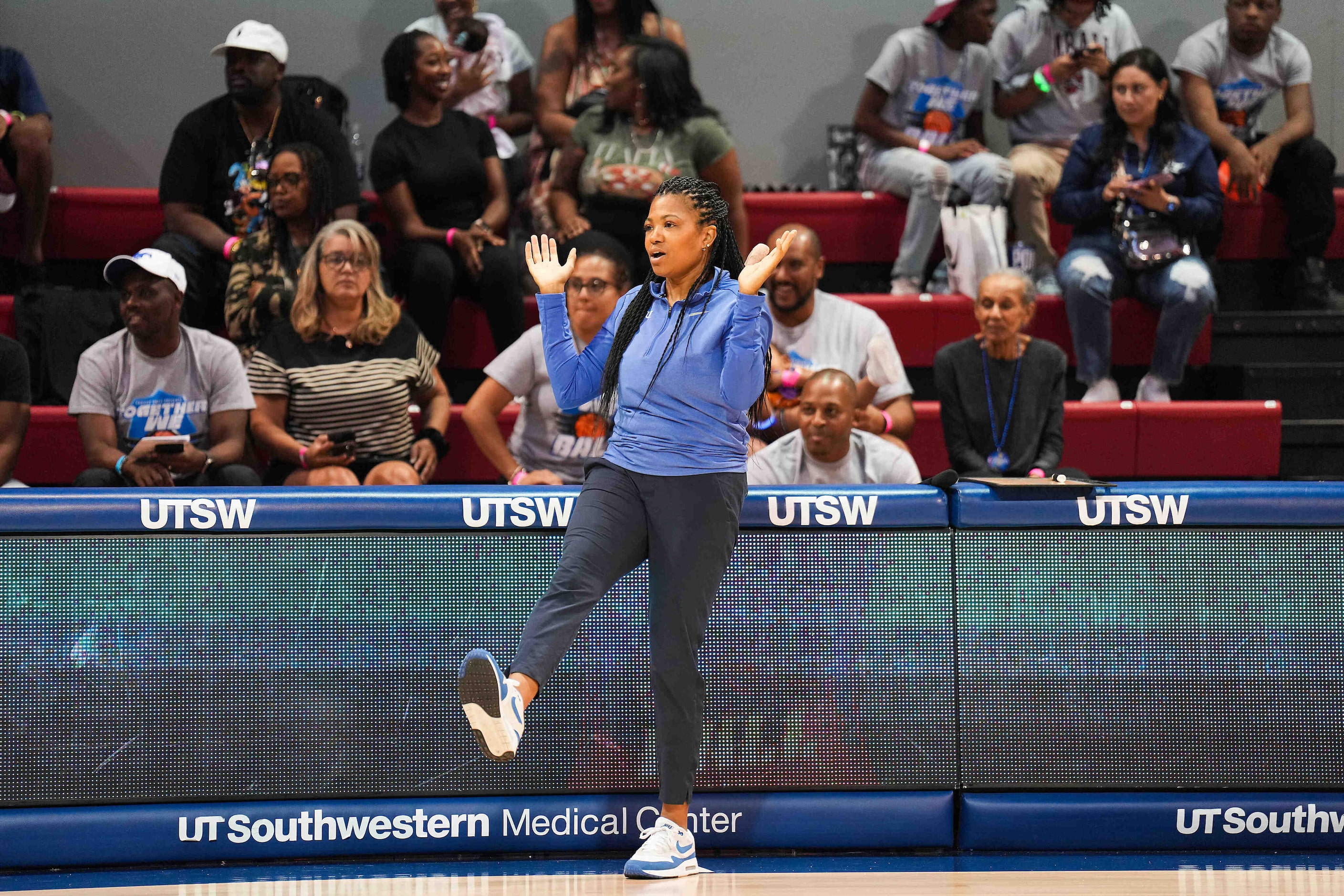 SMU women’s basketball coach Toyelle Wilson dances on the sidelines while coaching the white...