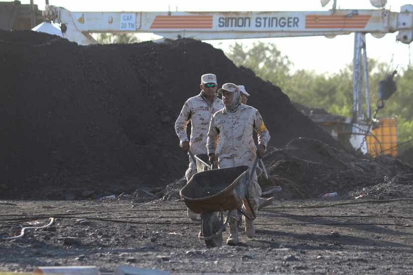 Dos soldados mexicanos empujan carretillas en las labores de rescate de 10 mineros atrapados...