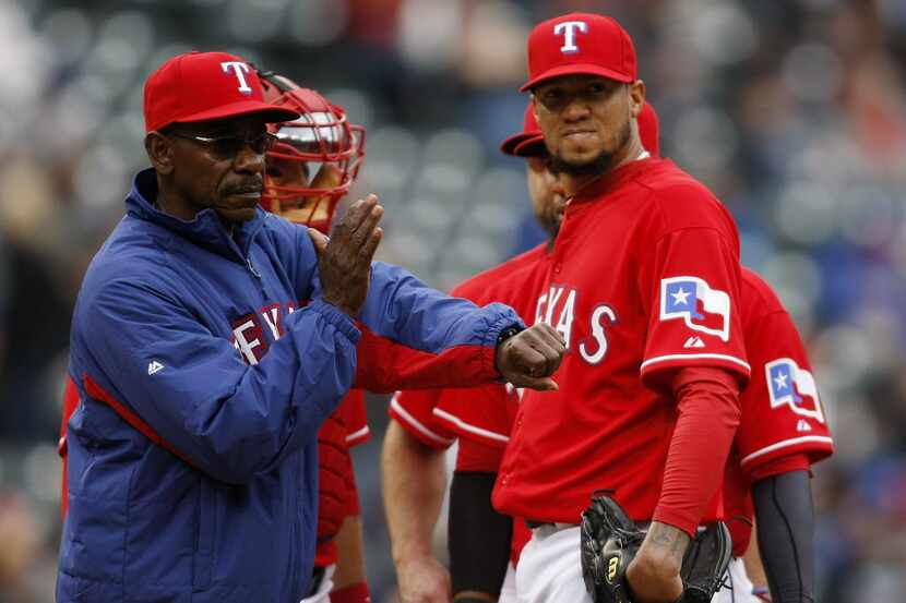 Texas Rangers manager Ron Washington relieves Hector Noesi, right, with Pedro Figueroa in...