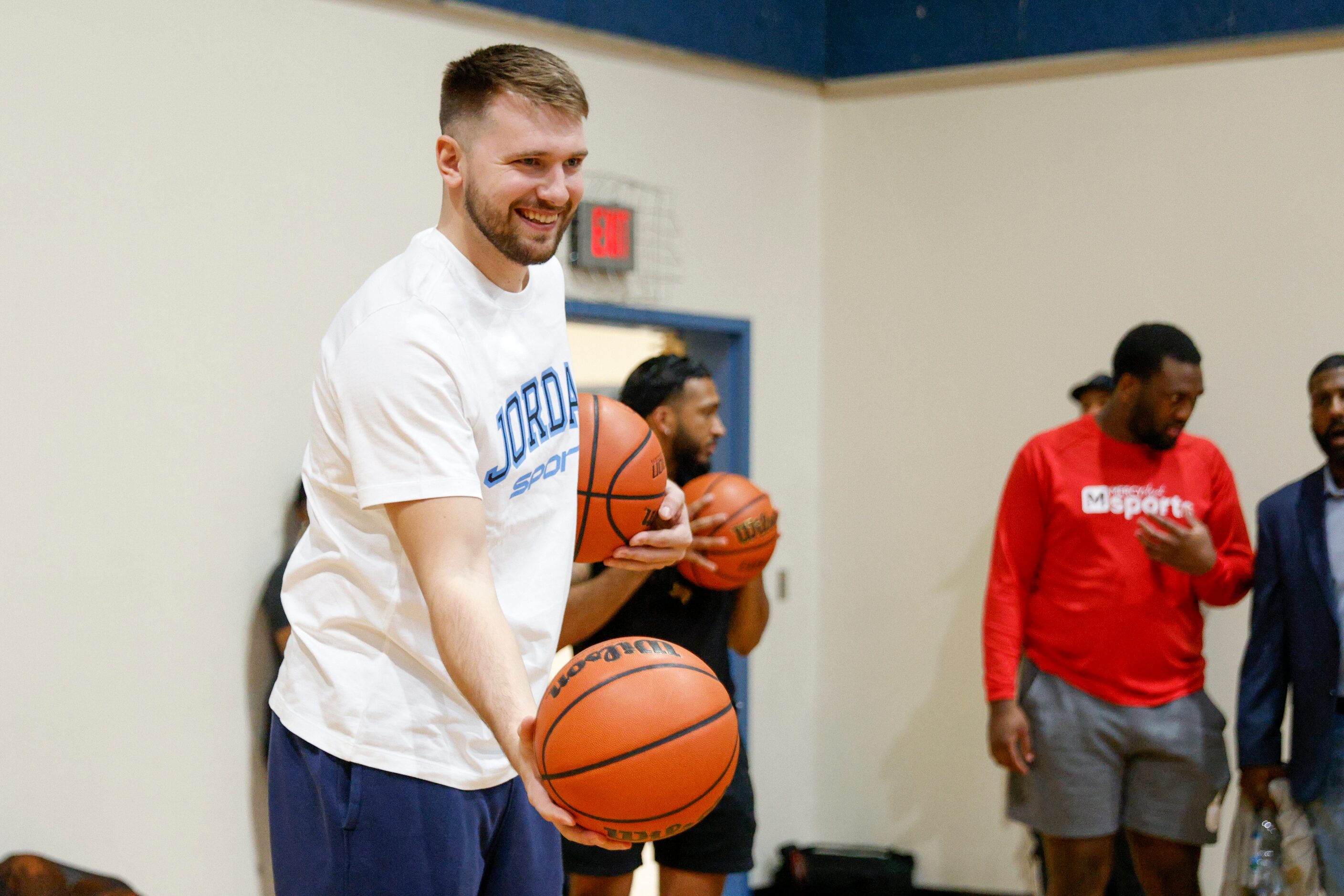 Dallas Mavericks guard Luka Doncic hands the ball back to a kid during a children’s...