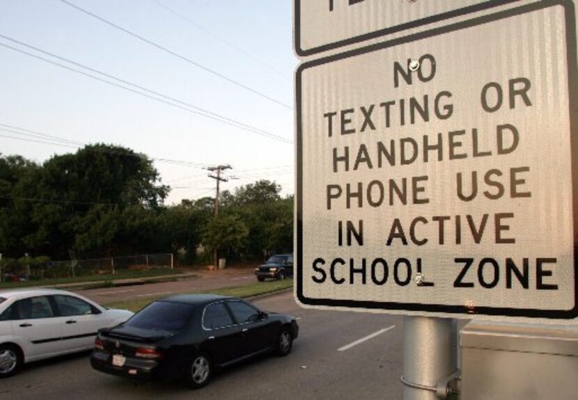 Cars pass through a school zone at Camp Wisdom Road and Wilcox Drive in Dallas. A state law...