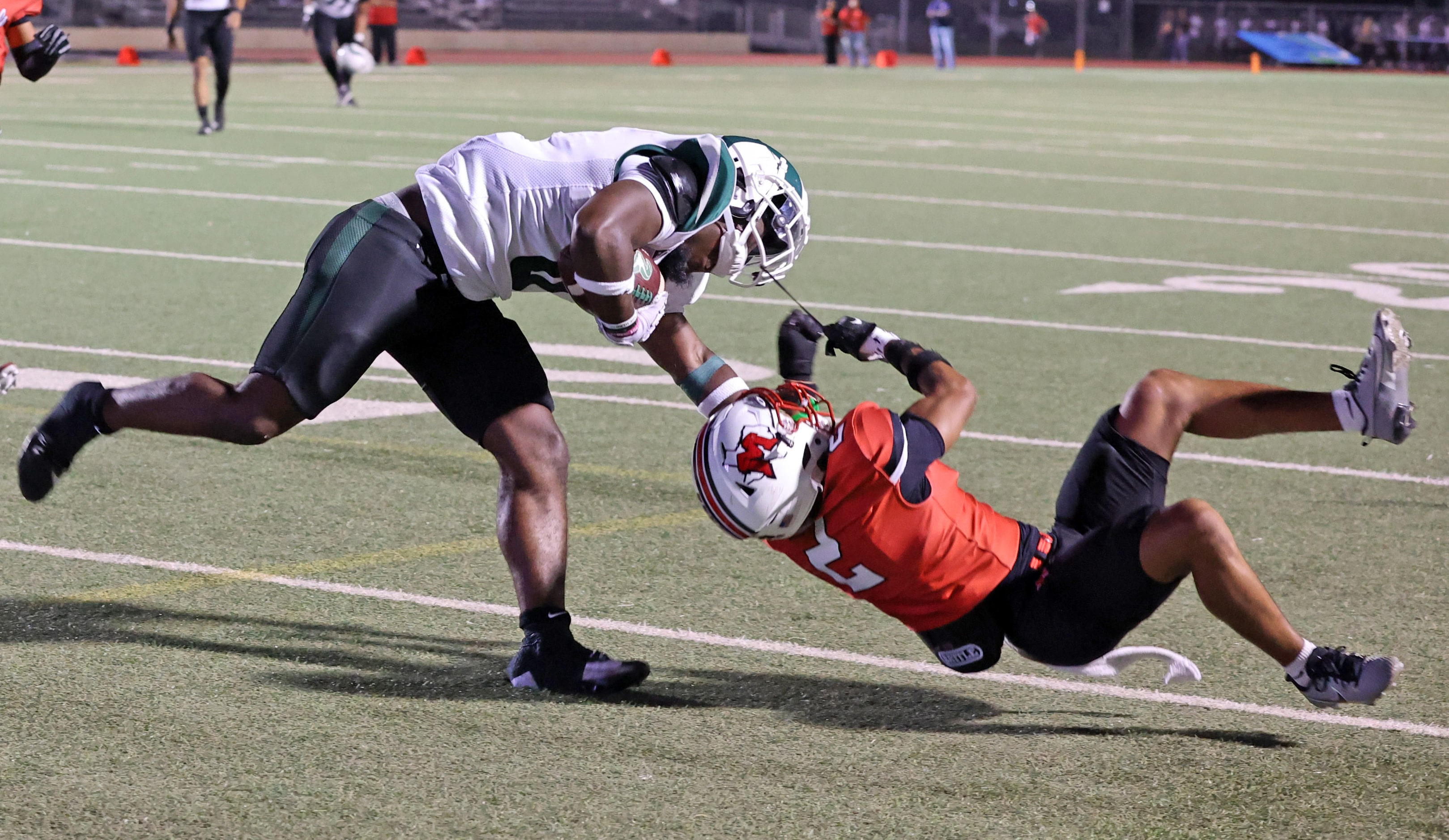 Richardson Berkner High Donte Doyle (0) gets tackled by Irving MacArthur High defender...