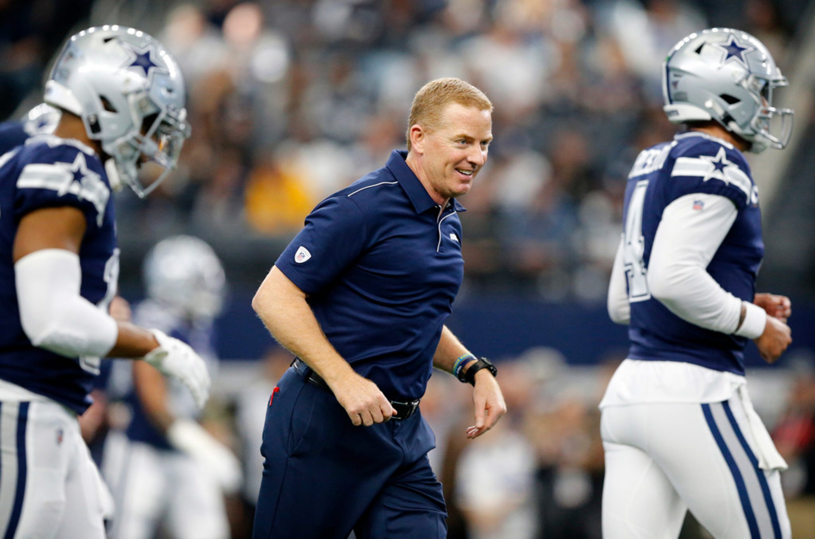 Dallas Cowboys head coach Jason Garrett leads his team down the field during pregame warmups...