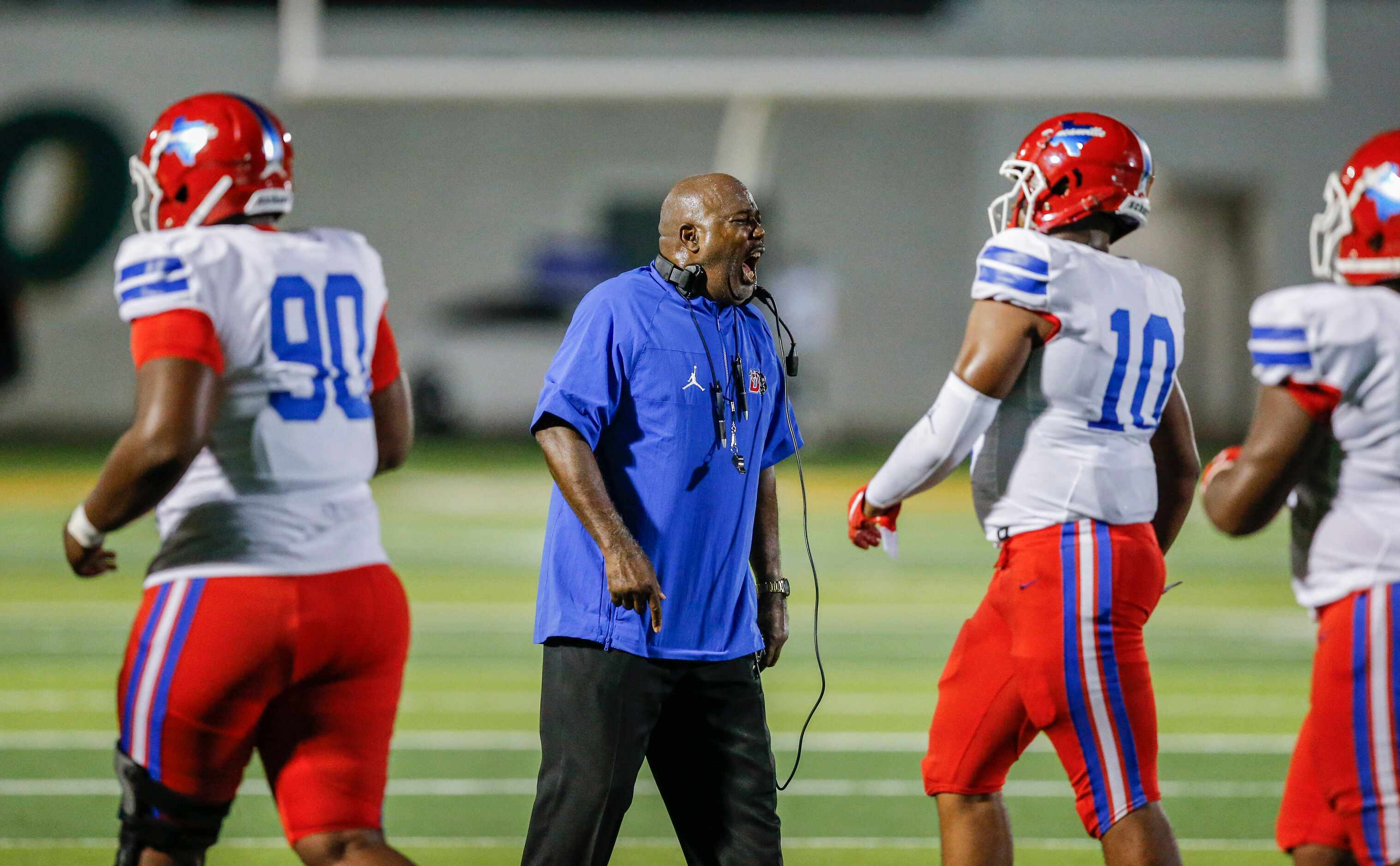 Duncanville head coach Reginald Samples shouts instructions to his players during the first...