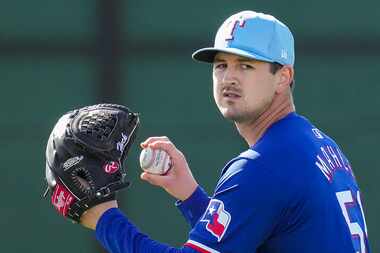 Texas Rangers pitcher Tyler Mahle plays catch in the outfield during a spring training...