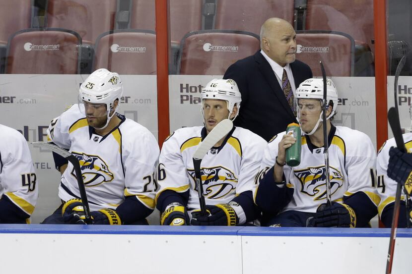 Nashville Predators head coach Barry Trotz, rear watches during the third period of an NHL...