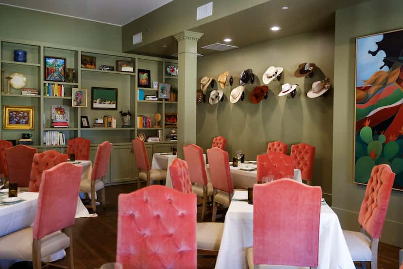 Different wall paintings and Chef Dre's cowboy hat collection on the second floor of Harvest...