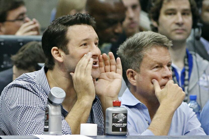 Dallas Cowboys quarterback Tony Romo watches action from courtside seats during the second...