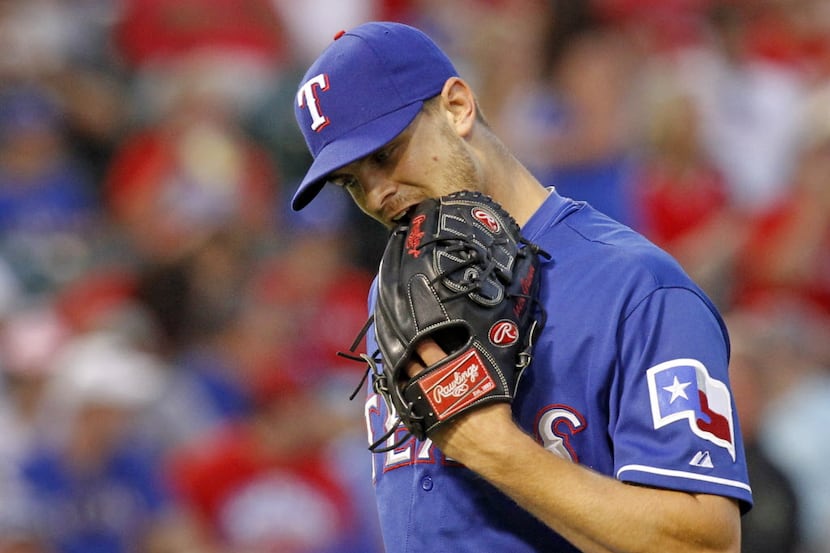 Texas Rangers starting pitcher Justin Grimm (51) bites his glove as he is pulled from the...