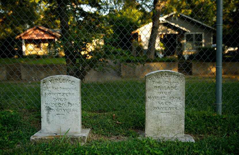 Military gravestones line the fence of the Confederate Cemetery, located in the middle of a...