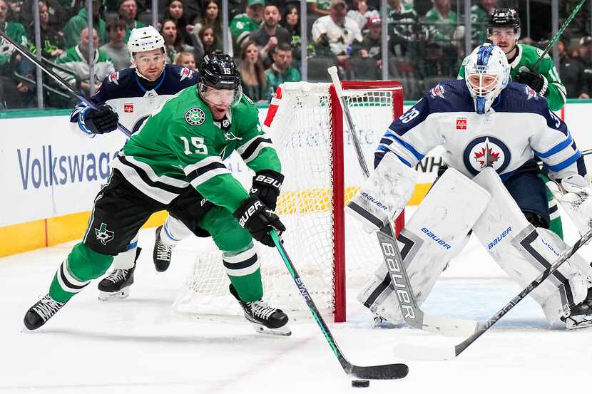 Dallas Stars center Craig Smith (15) reaches for the puck in front of Winnipeg Jets...