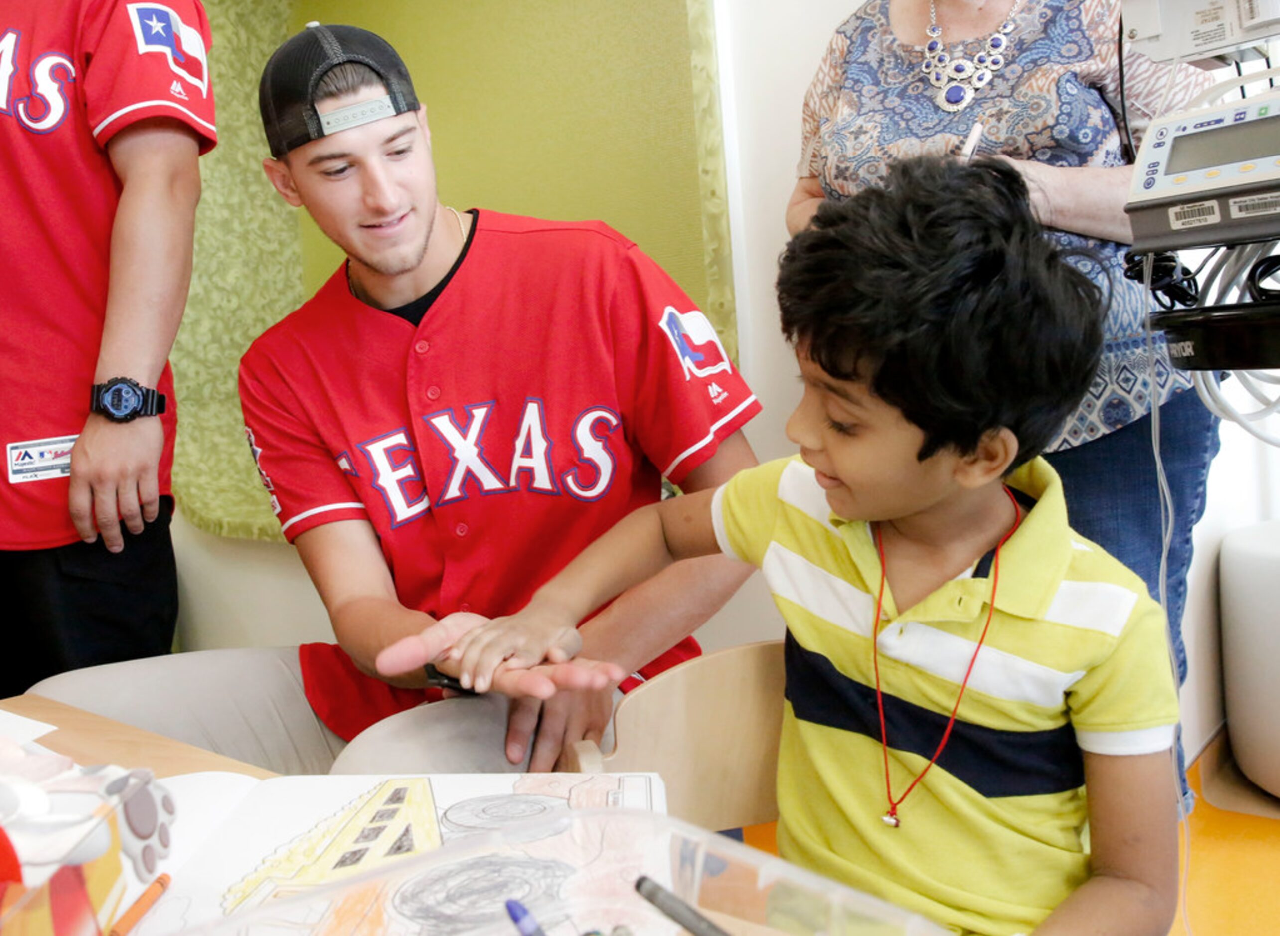 Texas Rangers pitcher Brett Martin gets five from 5-year-old patient Ishanth Somerreddy at...