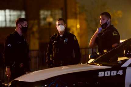 Police secure the area near Dallas' West End District where a suspect engaged gunfire with...