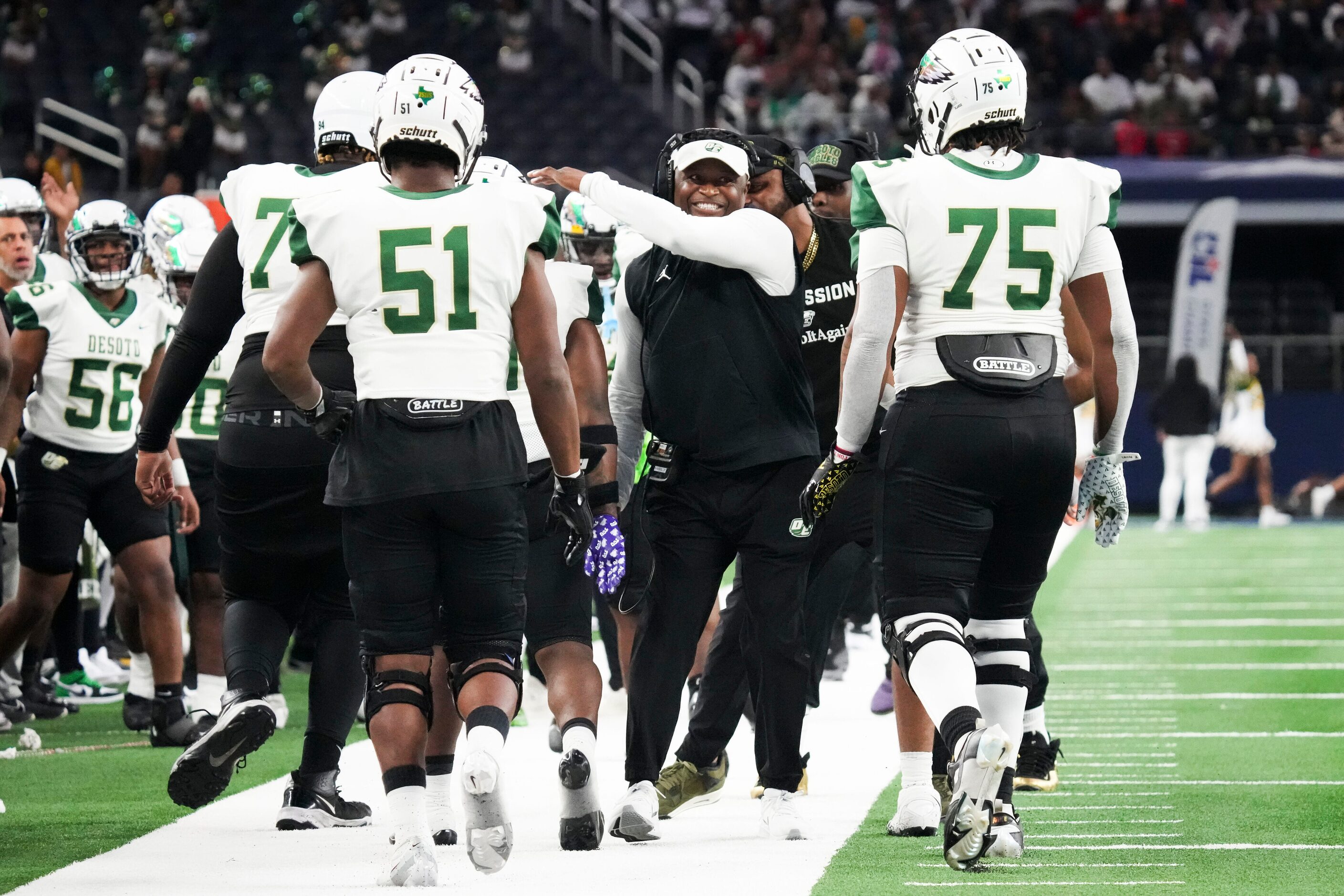 DeSoto head coach Claude Mathis celebrates with players after score during the first half of...