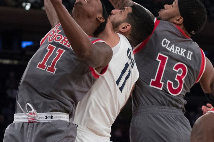 St. John's forwards Tariq Owens (11) and Marvin Clark II (13) battle for the ball with...