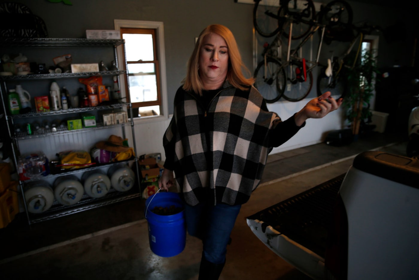 Mayor Jess Herbst carries a bucket to feed her cattle at her farm in New Hope.