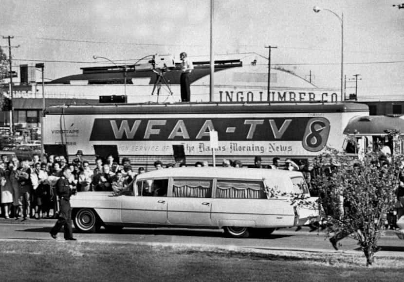 In this Nov. 22, 1963 file photo, people line the street as the hearse bearing the body of...